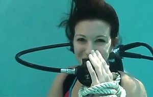 Scuba girl tied to pool ladder  