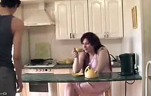 Redhead milf has sex in the kitchen with a young boy