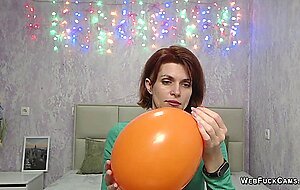 Redhead Milf plays with balloon on webcam